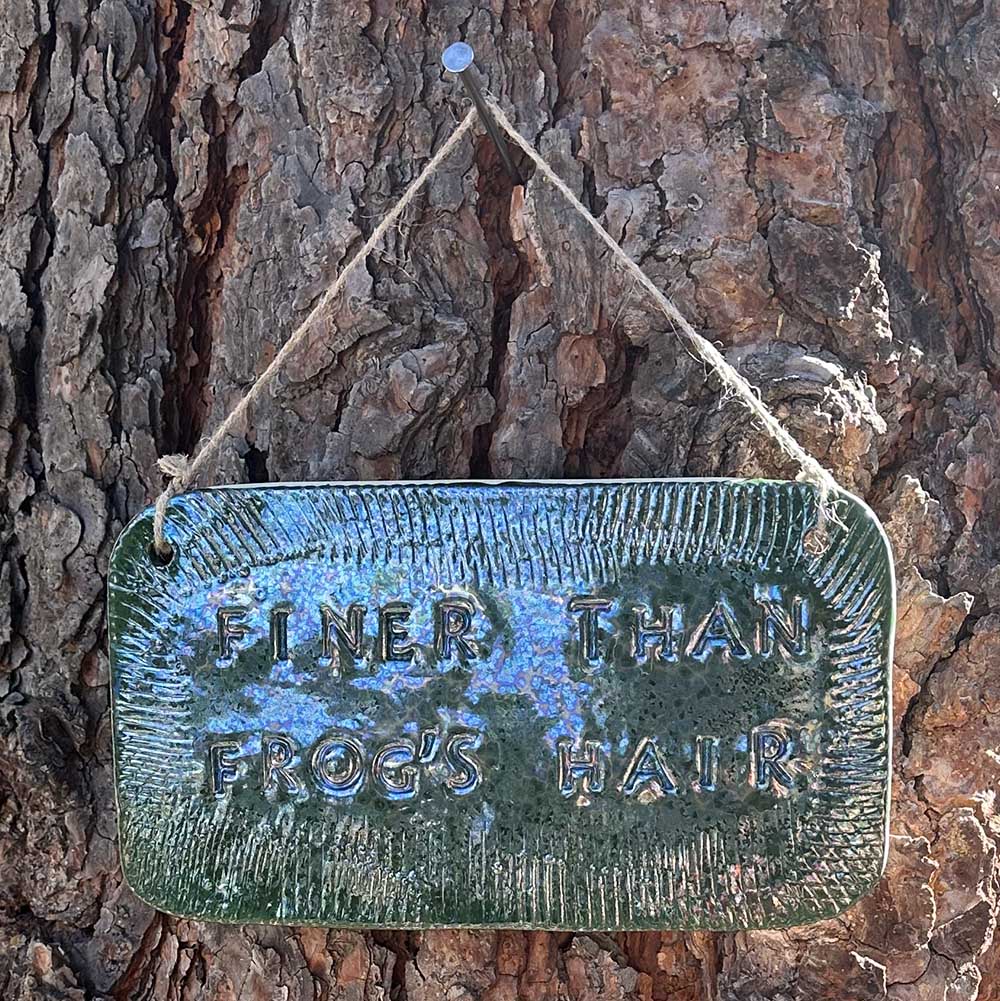 "finer than frog's hair" ceramic hanging sign in june bug with texture border