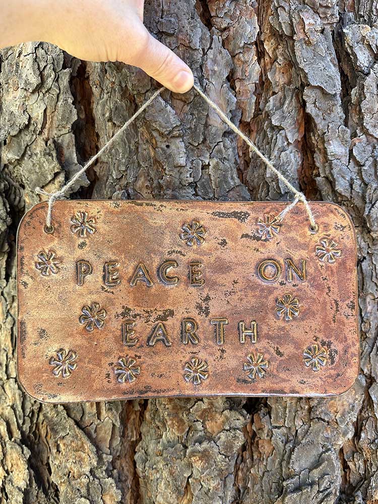 "peace on earth" hanging ceramic sign in ancient copper with asterisk stamp