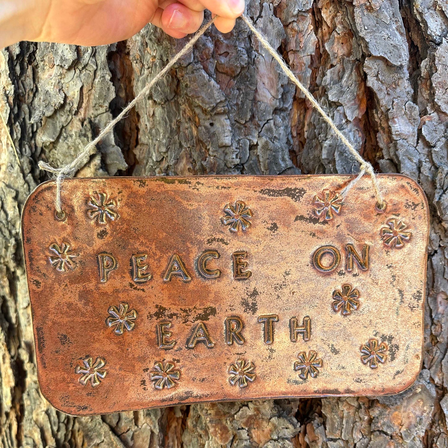 "peace on earth" hanging ceramic sign in ancient copper with asterisk stamp