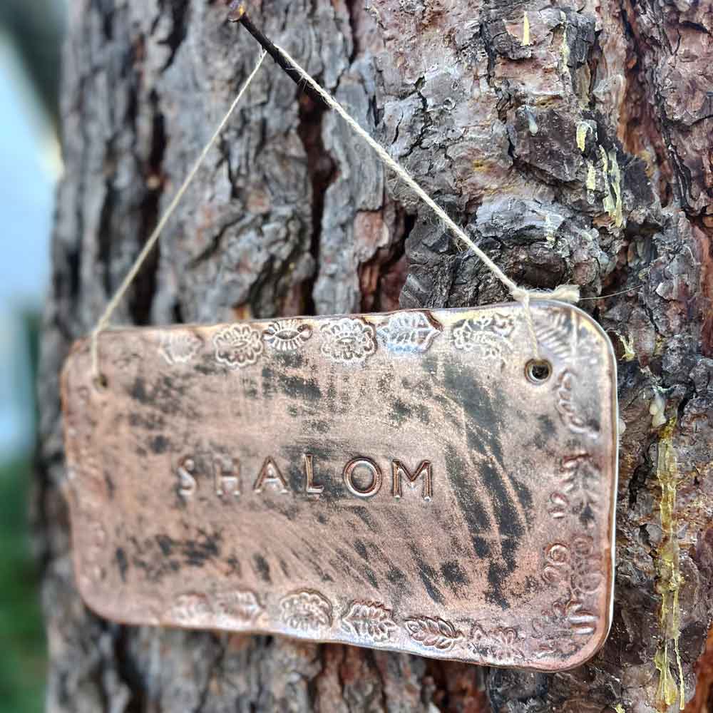 "shalom" hanging ceramic sign in copper with stamped border