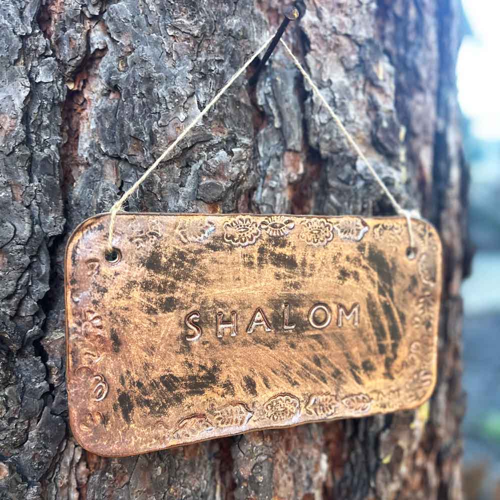 "shalom" hanging ceramic sign in copper with stamped border