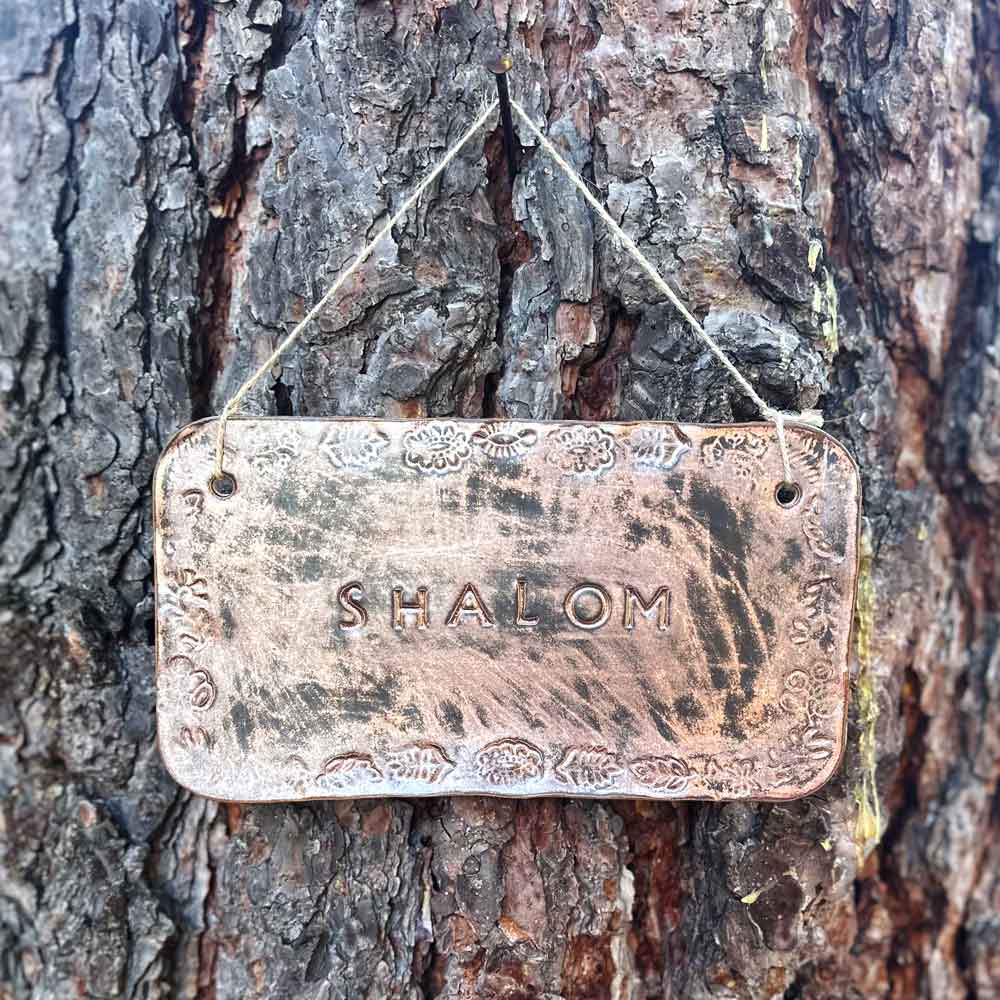 "shalom" hanging ceramic sign in copper with stamped border