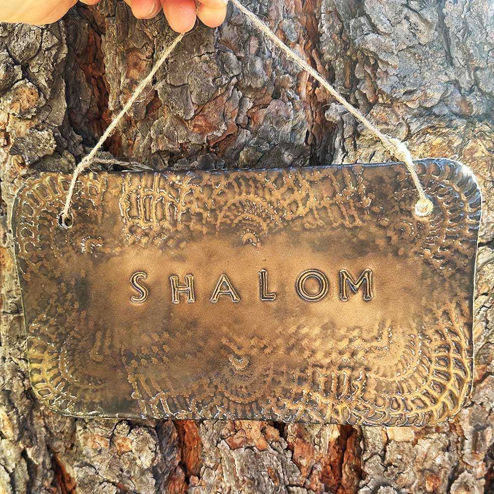 "shalom" hanging ceramic sign in gold with doily lace border