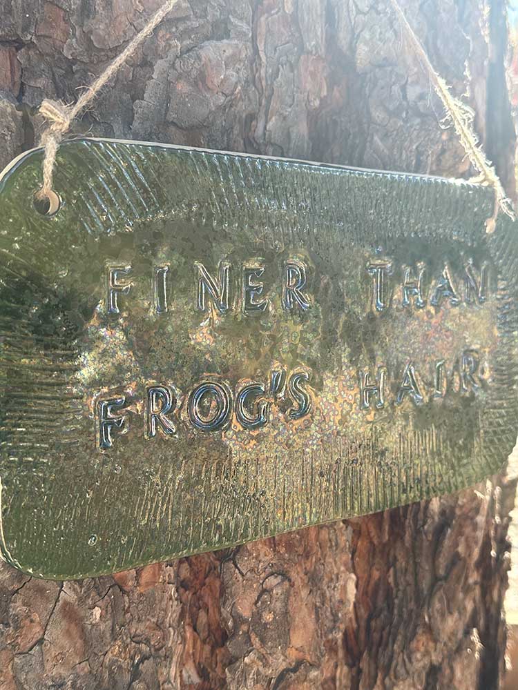 "finer than frog's hair" ceramic hanging sign in june bug with texture border