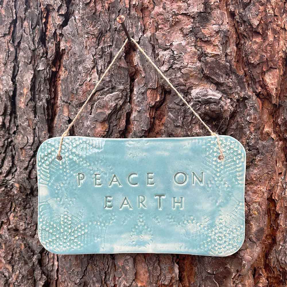'peace on earth" hanging ceramic sign in blue lagoon with all-over doily lace imprint