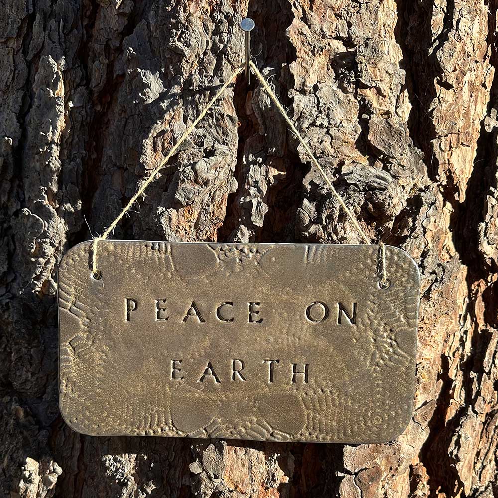 "peace on earth" hanging ceramic sign in gold with lace all-over imprint